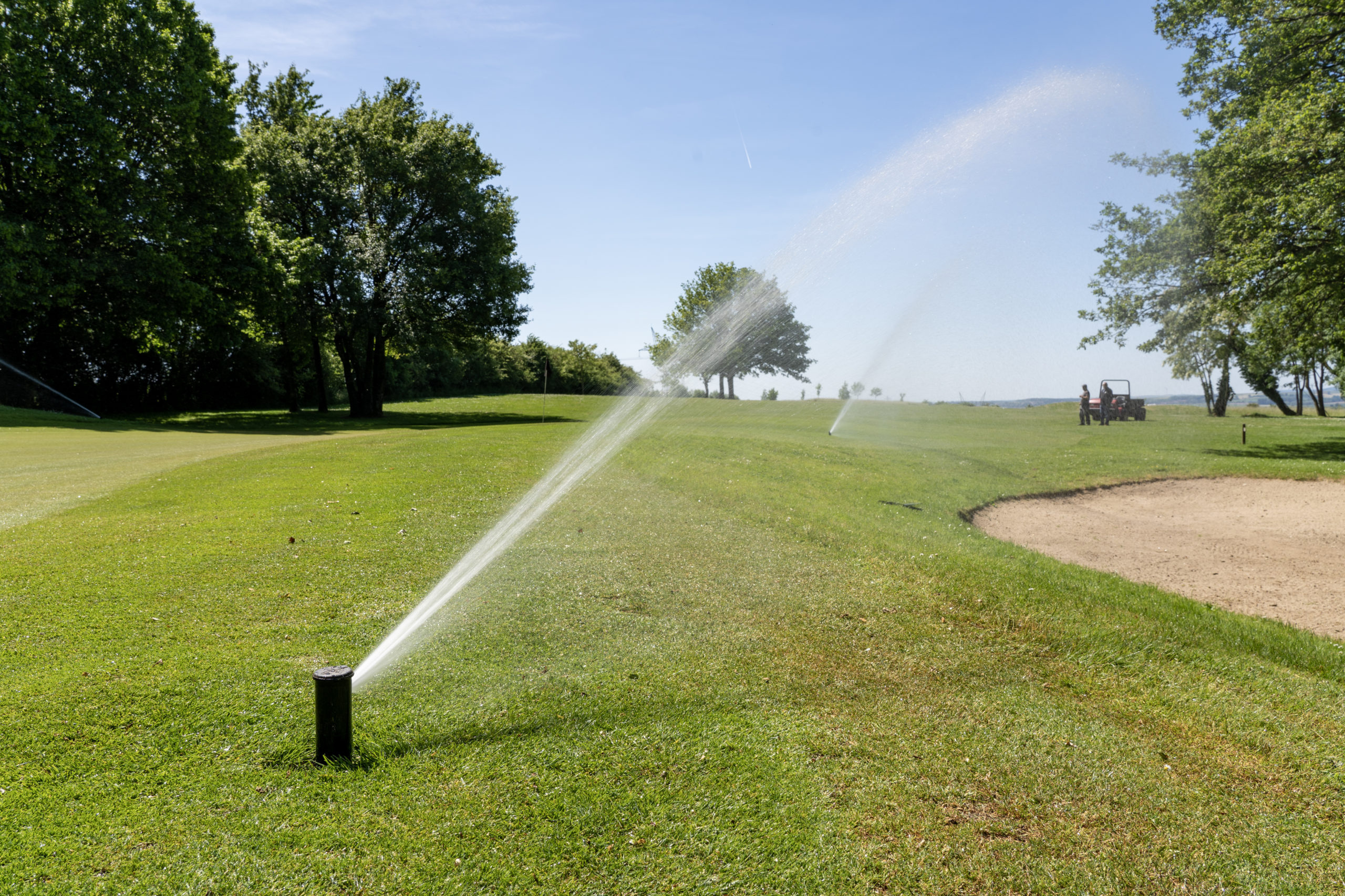 Buse d'arrosage en train de diffuser de l'eau sur un gazon de golf
