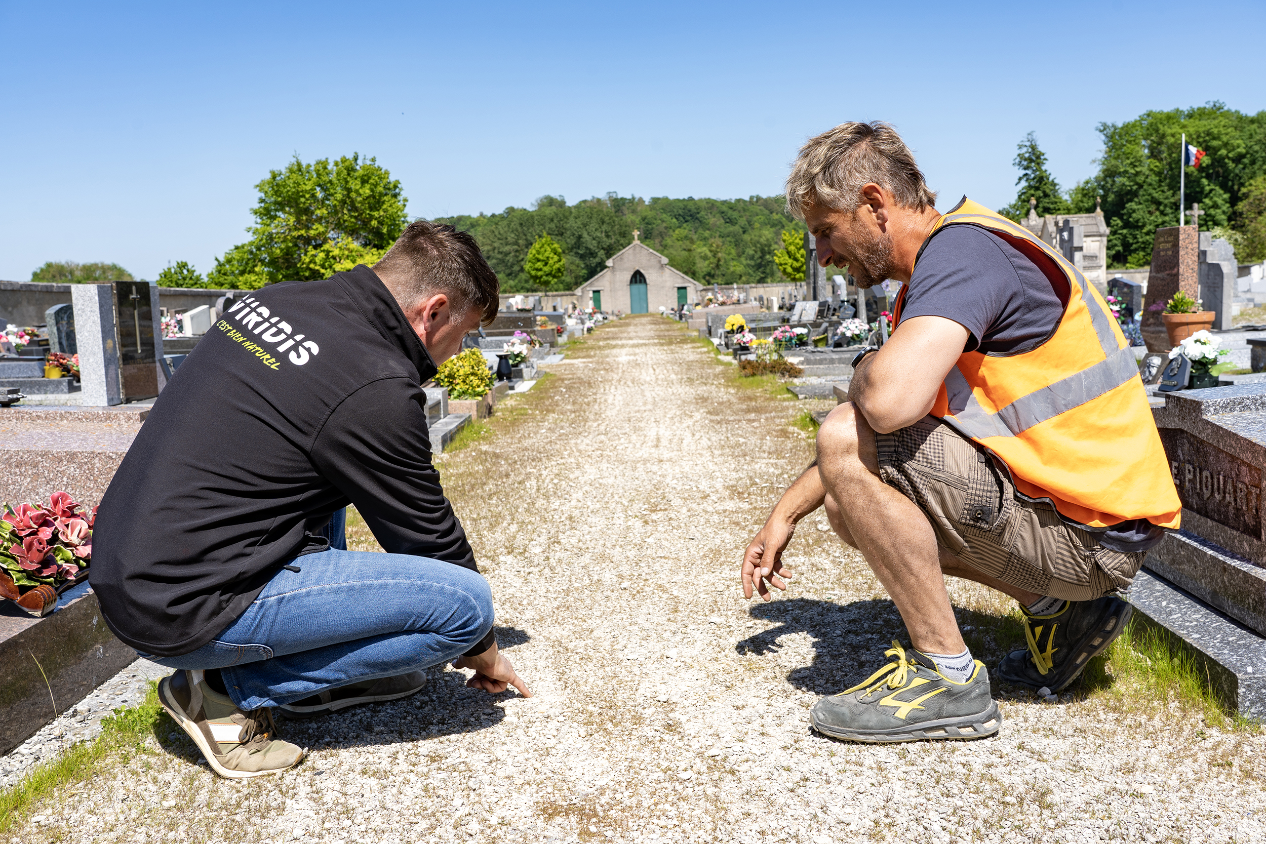 Photo de deux personnes regardant l'allée d'un cimetière